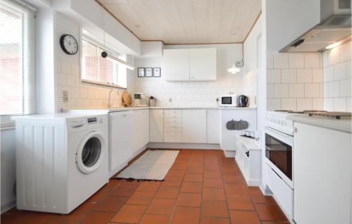 a kitchen with white cabinets and a washer and dryer at Three-Bedroom Holiday Home In Bredebro in Ballum