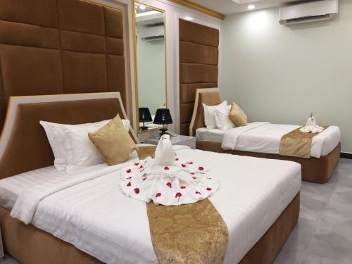 磅同省Kampong Thom Royal Hotel的酒店房间有两张床，床单是白色的