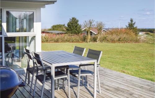 a wooden deck with a table and chairs on a house at Holiday Home Astersvej in Lemvig