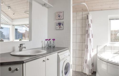 a bathroom with a sink and a washing machine at Nice Home In Lemvig With 3 Bedrooms, Sauna And Wifi in Lemvig