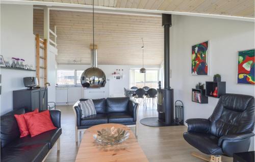 a living room with black leather furniture and a table at Holiday Home Astersvej in Lemvig