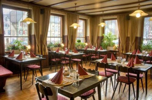 a restaurant with tables and chairs with red napkins on them at Zur alten Brücke in Schiltach