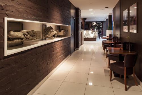 a restaurant with a brick wall and tables and chairs at Mercure Gdańsk Stare Miasto in Gdańsk