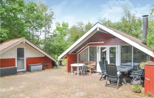 a cabin with a patio and a table and chairs at Holiday Home Søknudevej Iv in Ansager