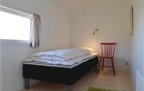 a bedroom with a bed and a red chair at Tina in Klegod