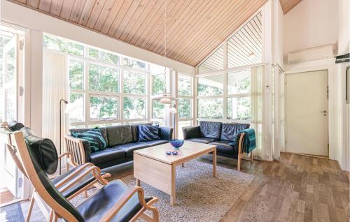 a living room with a couch and a table at Rubinsøen Skovhuse in Hasle