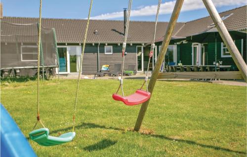three swings in a yard with a house at Nice Home In Idestrup With Sauna in Marielyst
