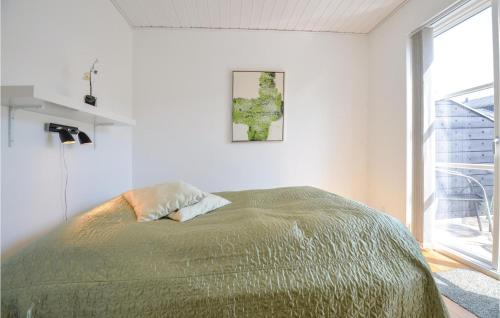 a bed in a white room with a large window at Torvet 518 in Ebeltoft