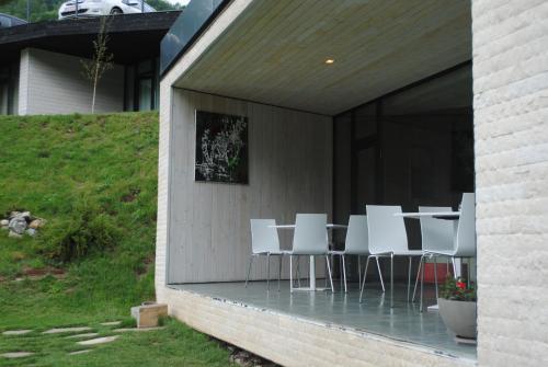 a group of white chairs and a table on a patio at Pensiunea Atra Doftana in Teşila