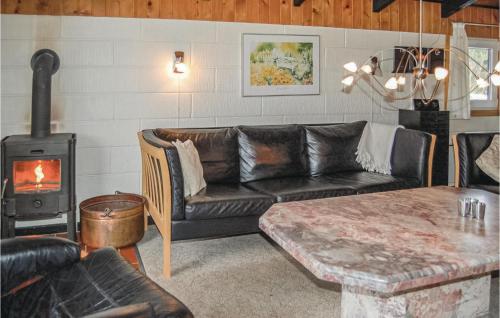 a living room with a couch and a wood stove at Holiday Home Sivvejen in Nørre Nebel