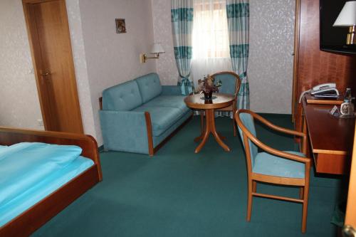 ein Wohnzimmer mit einem blauen Sofa und einem Tisch in der Unterkunft Gästehaus Wild in Oberasbach