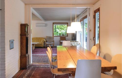a dining room with a wooden table and chairs at Four-Bedroom Holiday Home In Grasted in Græsted