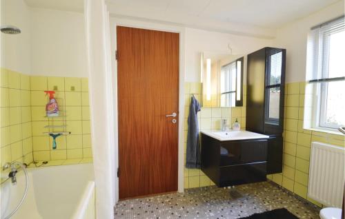 a bathroom with a sink and a wooden door at Holiday Home Nysted Xcix in Nysted
