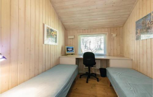 a room with two beds and a desk with a computer at Holiday Home Hejrevej Nexø Xii in Spidsegård