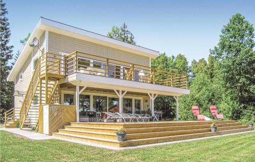 a large house with a deck and a patio at Amazing Home In Bolmsö in Bolmsö