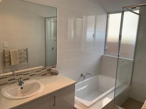 een badkamer met een wastafel, een douche en een bad bij Carpe Diem South #3 in Busselton