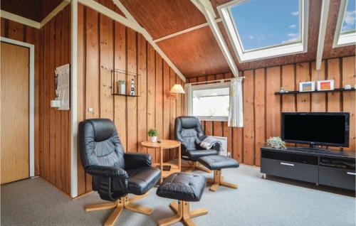 a living room with two chairs and a flat screen tv at Holiday Home Lakolk Iv Denmark in Bolilmark