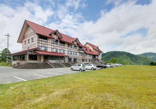 a large building with cars parked in a parking lot at Shirabiso Kogen Amanogawa in Iida