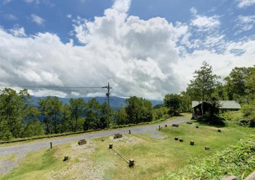 a road with a group of animals in a field at Shirabiso Kogen Amanogawa in Iida