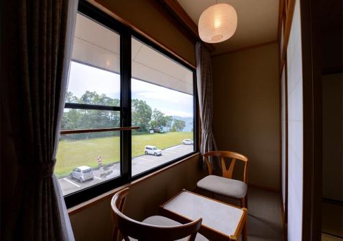 a room with a window and a table and chairs at Shirabiso Kogen Amanogawa in Iida