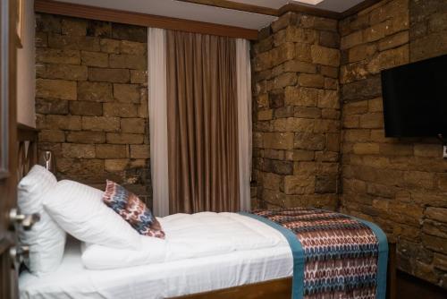 a bed in a room with a brick wall at Maajid Boutique Hotel in Baku