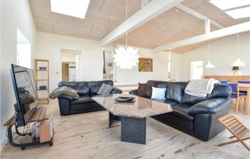 a living room with a black leather couch and a table at Det Gamle Gasværk in Bogense