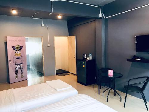 a room with a bed and a table and a door at SleepCatsHostel in Bangkok