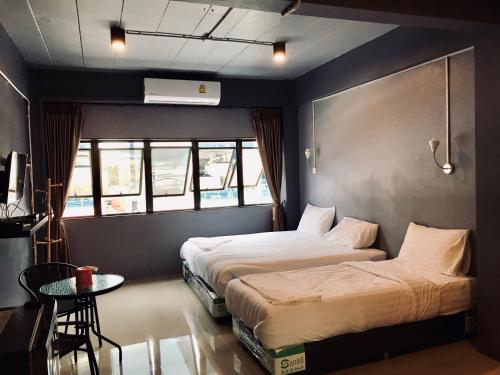 een hotelkamer met 2 bedden en een tafel bij SleepCatsHostel in Bangkok