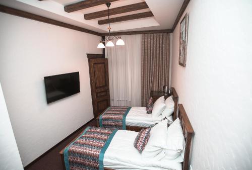 a hotel room with two beds and a tv at Maajid Boutique Hotel in Baku