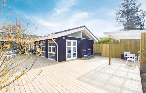 a black house with a deck and a patio at Two-Bedroom Holiday Home In Farevejle in Fårevejle