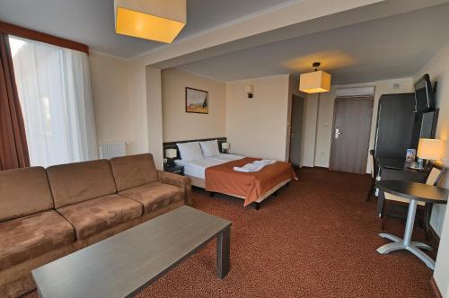 a hotel room with a couch and a bed at Hotel Martex in Płońsk