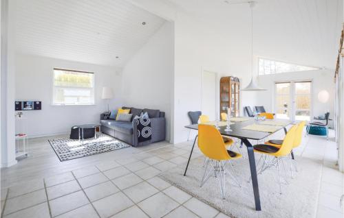 a living room with a table and yellow chairs at Two-Bedroom Holiday Home In Farevejle in Fårevejle