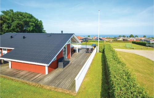 a small red building with a wooden deck at Holiday Home Bygmarken V in Sjølund