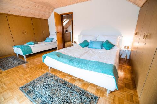 a bedroom with a large bed with blue pillows at Holiday Home Mountain View in Ljubno