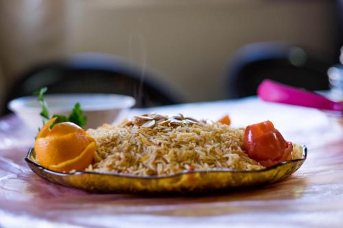 a plate of food with rice and fruit on a table at Mhna guest house in Ajloun