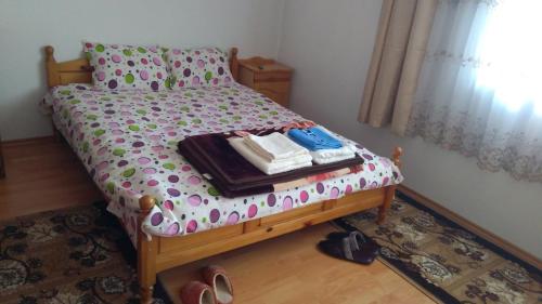 a bedroom with a bed with a dresser and shoes on it at Айрови in Sarnitsa