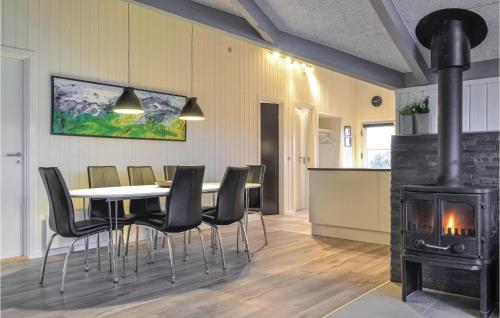 a dining room with a table and chairs and a stove at Three-Bedroom Holiday Home In Hvide Sande in Bjerregård
