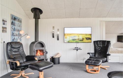 Una sala de estar con dos sillas y una chimenea. en Holiday Home Tingodden Hvide Sande Vi, en Hvide Sande