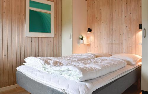 a large bed in a room with wooden walls at Awesome Home In Harbore With Kitchen in Harboør
