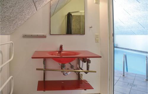 La salle de bains est pourvue d'un lavabo rouge et d'un miroir. dans l'établissement Stunning Home In Oksbl With Private Swimming Pool, Can Be Inside Or Outside, à Oksbøl
