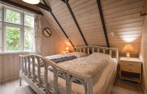 a bedroom with a bed in a room with wooden walls at Awesome Home In Ebeltoft With 4 Bedrooms And Wifi in Ebeltoft
