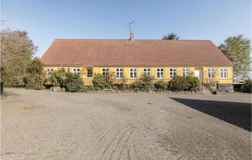 a large yellow house with a red roof at Buskegaard in Østermarie