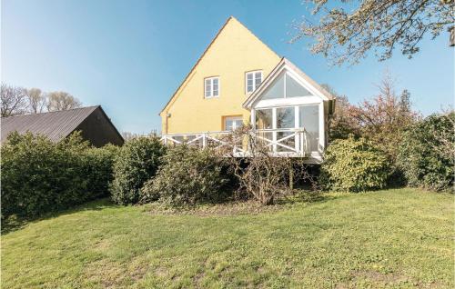 a yellow house on a hill with a yard at Buskegaard in Østermarie