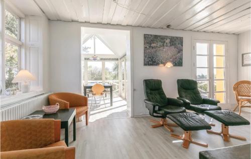 a living room with green chairs and a table at Buskegaard in Østermarie