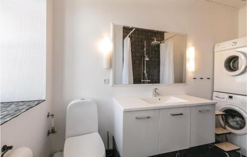 a bathroom with a sink and a washing machine at Buskegaard in Østermarie