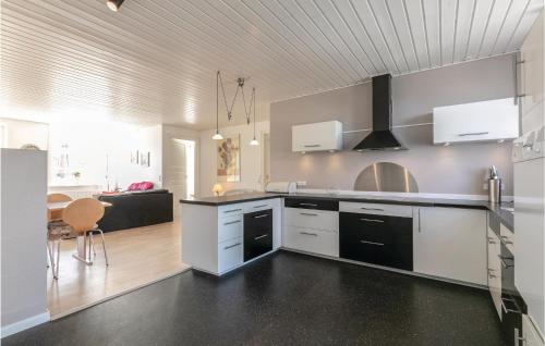 a kitchen with white cabinets and black counter tops at Buskegaard in Østermarie