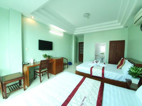 a hotel room with two beds and a television at Khách sạn Trường Sơn in Ho Chi Minh City