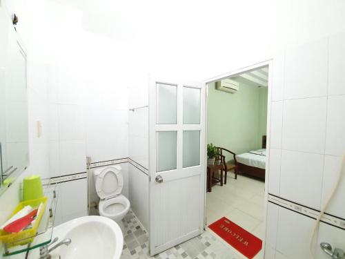 a bathroom with a toilet and a sink and a mirror at Khách sạn Trường Sơn in Ho Chi Minh City