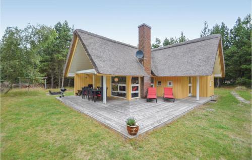 a house with a deck with red chairs on it at Holiday Home Vestervej Rømø Ix in Rømø
