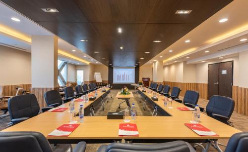 a large conference room with long tables and chairs at Ramada Hotel & Suites by Wyndham Al Qassim in Al Bukayriyah